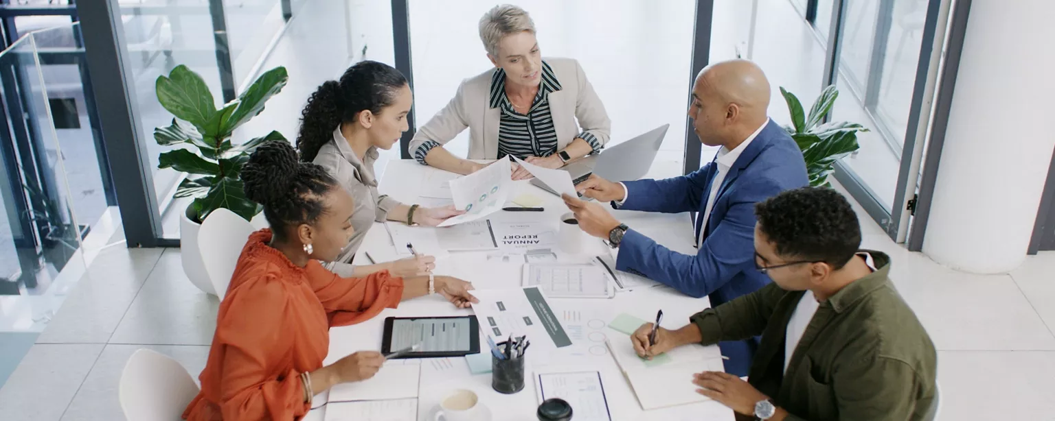 A business leader meets with her team to review the company's financial reports.