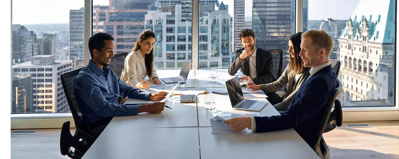 At a conference table in a high-rise office, finance leaders meet with highly skilled consultants to discuss finance priorities for the business.