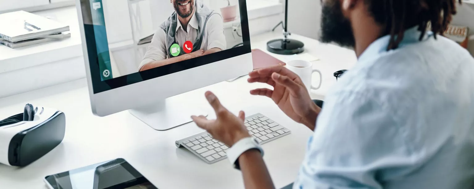 Two men who are work colleagues talking via a video conference call.