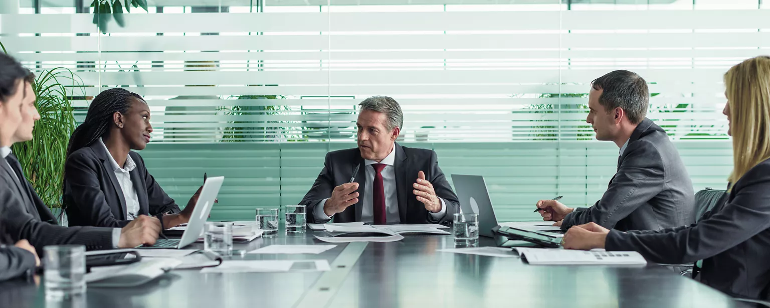 Board members seated around a conference table during a corporate governance discussion.