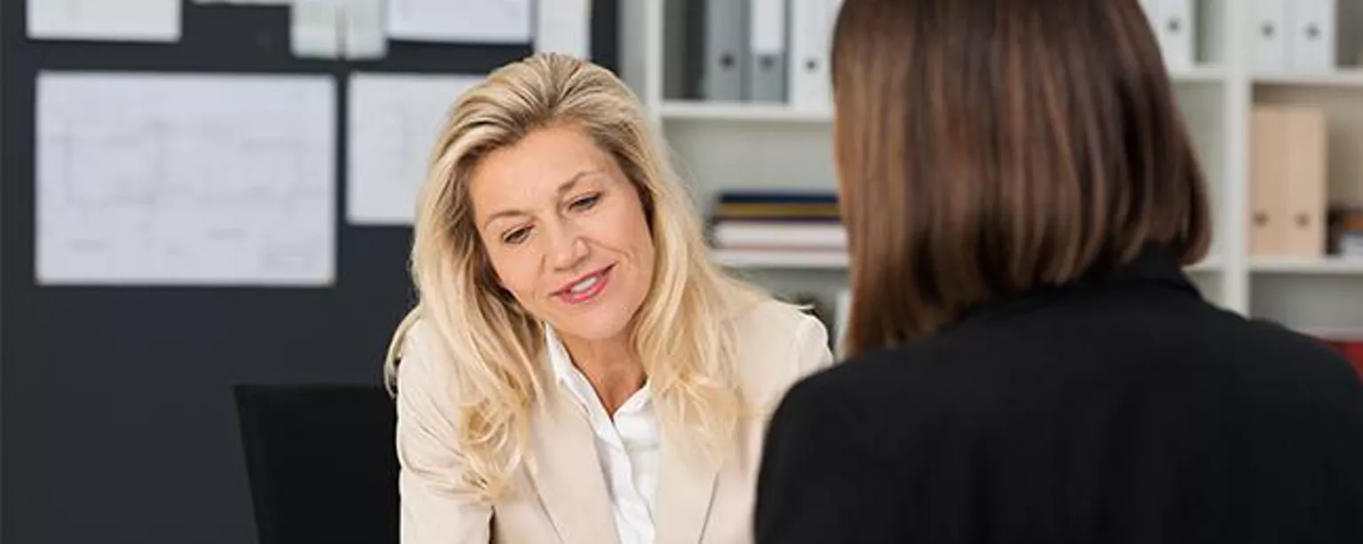 The Senior Administrative Assistant Position Is Within Reach — Woman in office showing notebook to another woman