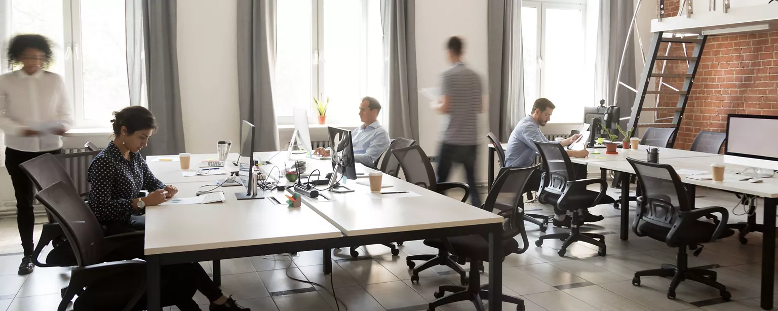 Open office setting with people moving around and working