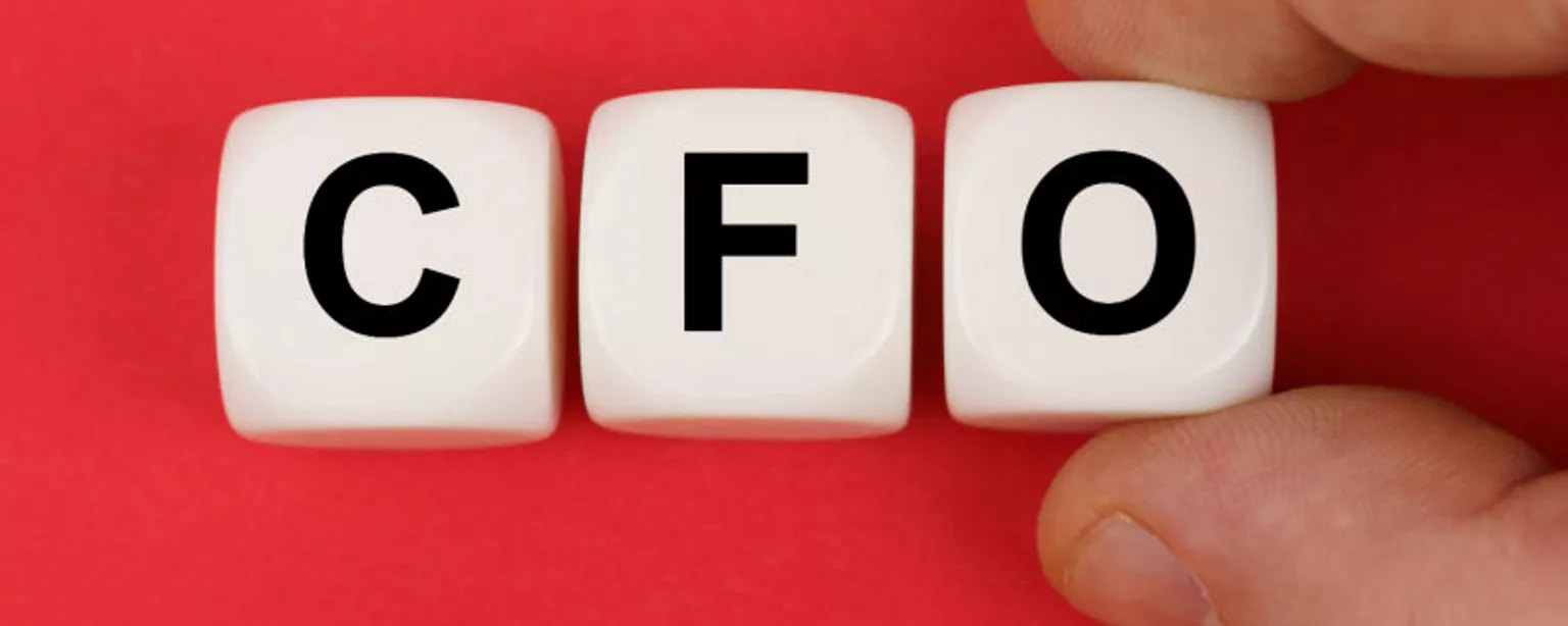 Three white cubes with the black letters "C," "F" and "O" are held between a thumb and finger against a red background.
