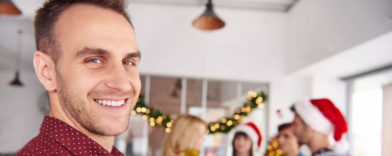 Man walking towards his colleagues at the work Xmas party