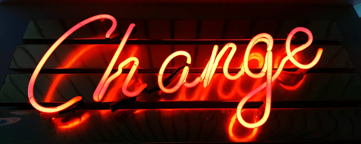 Das Wort “Change” in orange leuchtender Neonschrift