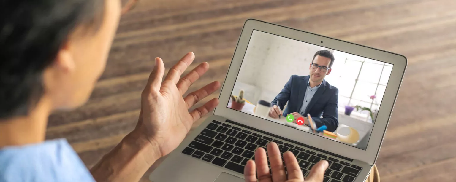 A person talks remotely on a laptop.