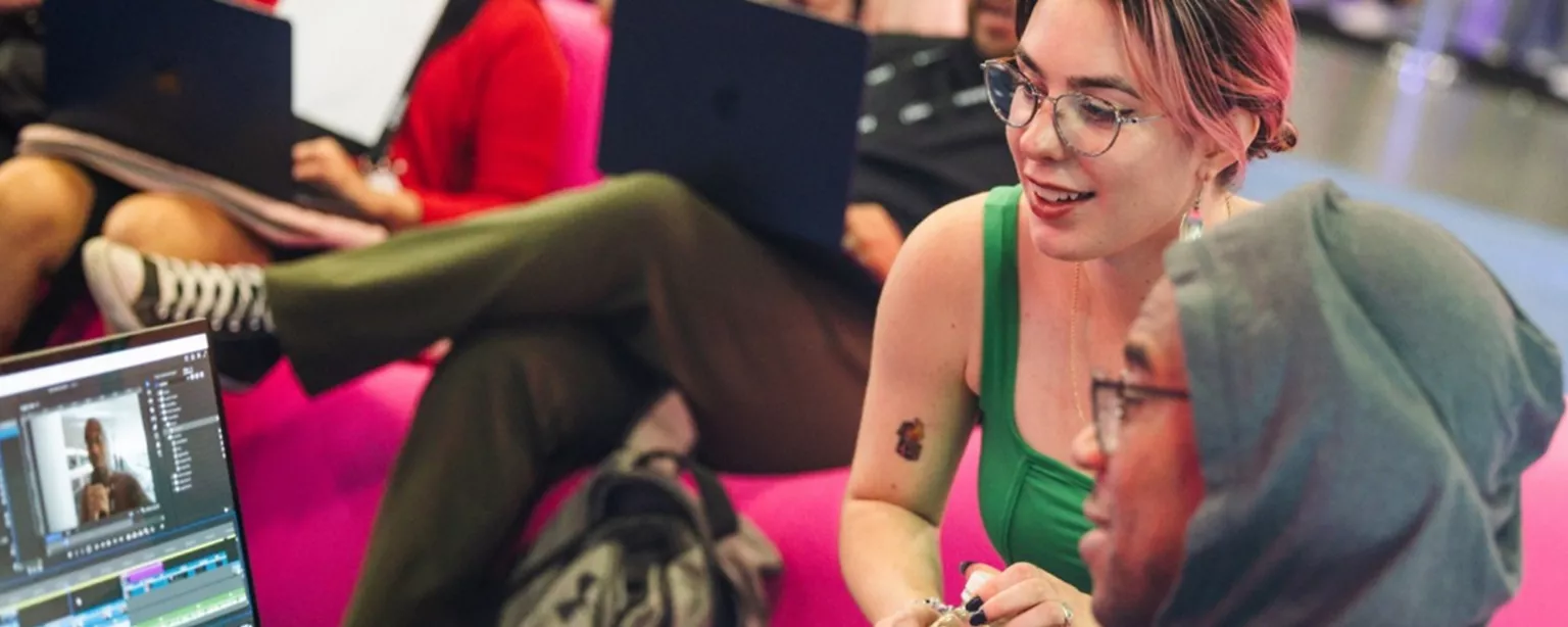 Two creative professionals collaborate on video editing at Adobe MAX.