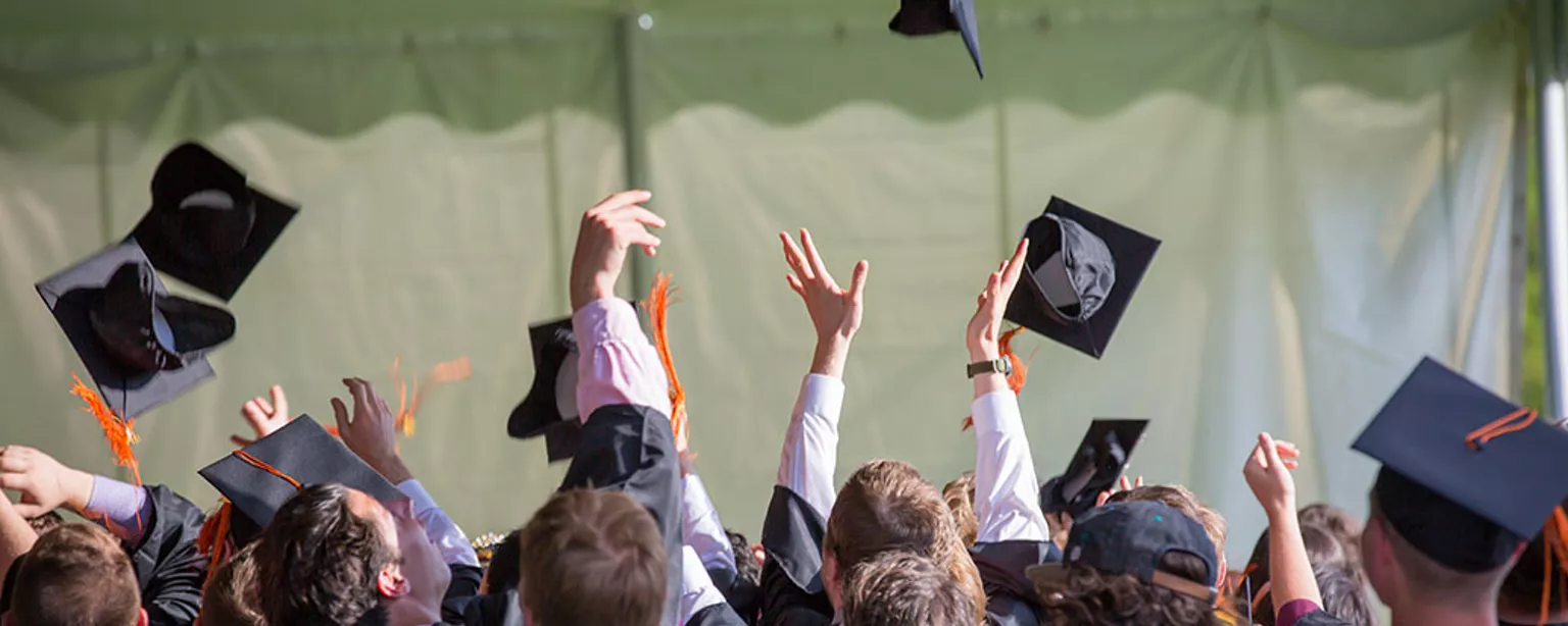 Groep afgestudeerden gooit hoed in de lucht