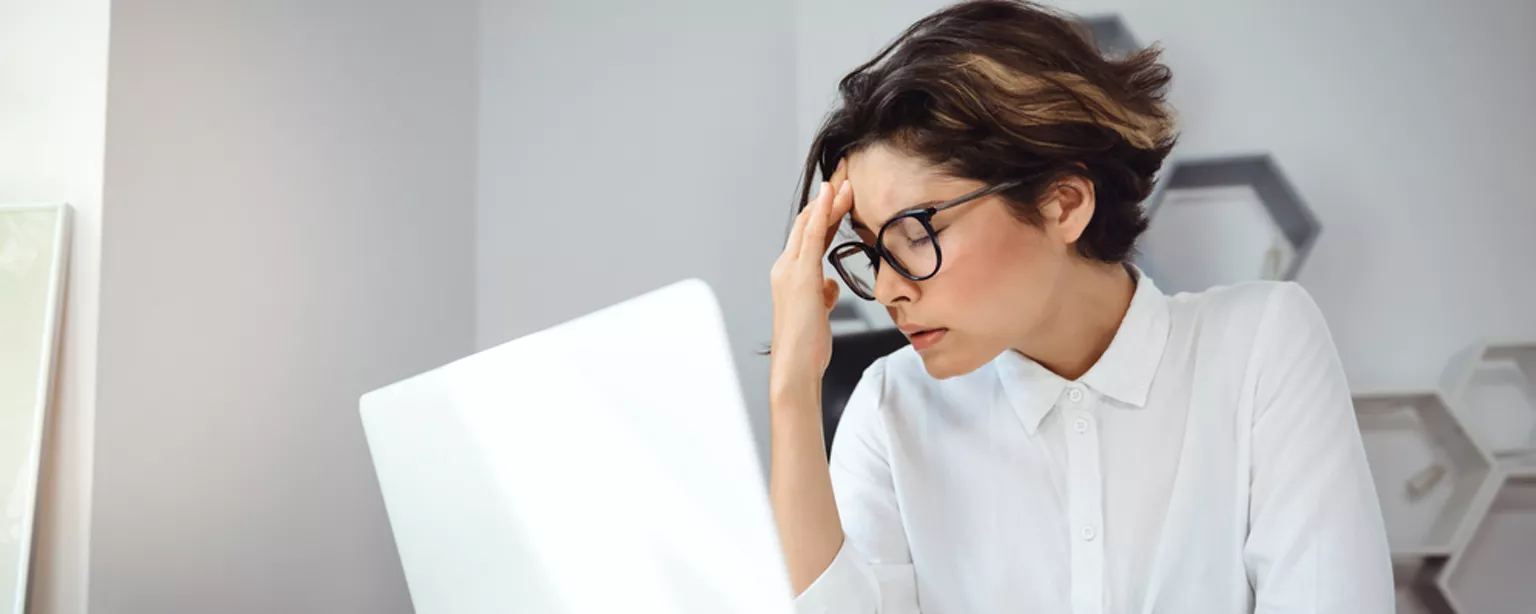 Photo of frustrated worker at desk having a bad day at work.