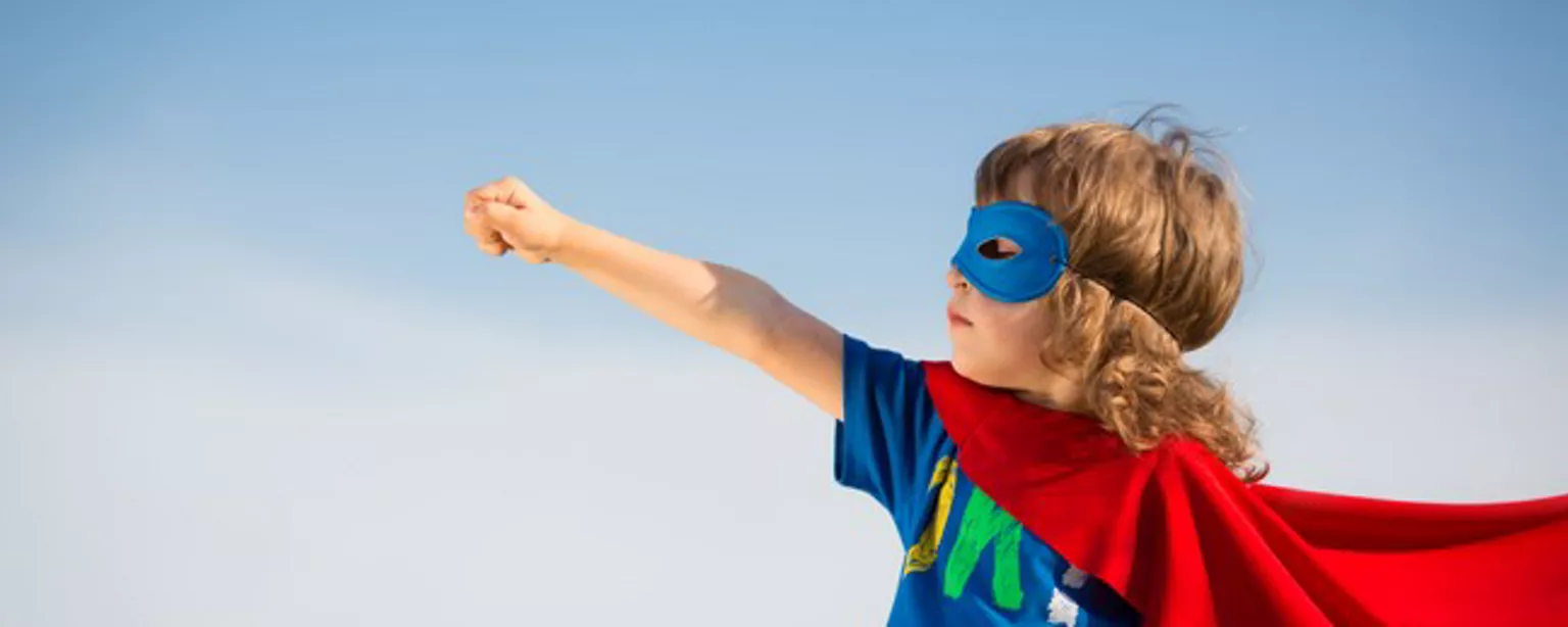 A child in a superhero outfit reached to the sky