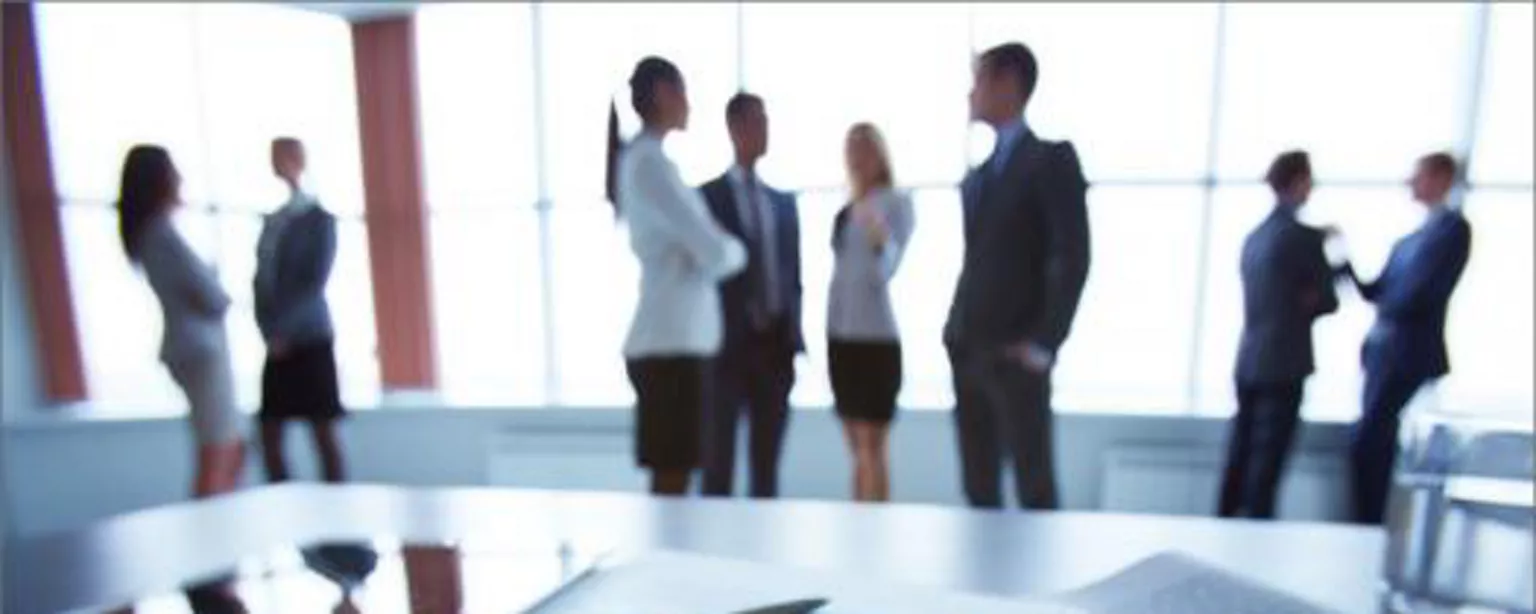 Graphs on a table with professionals in the background