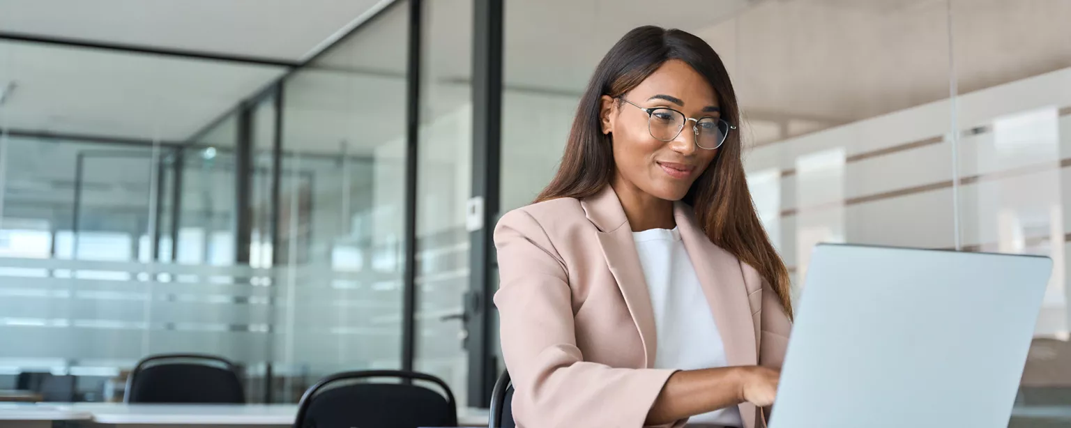 A legal professional working on her laptop in an office.