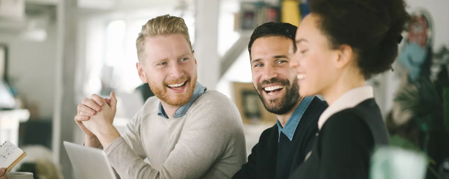 Happy workers around a table.