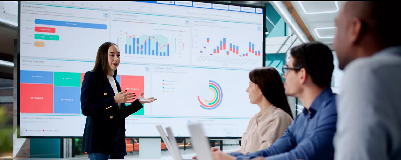 Finance professionals reviewing business data and reports on a large screen.