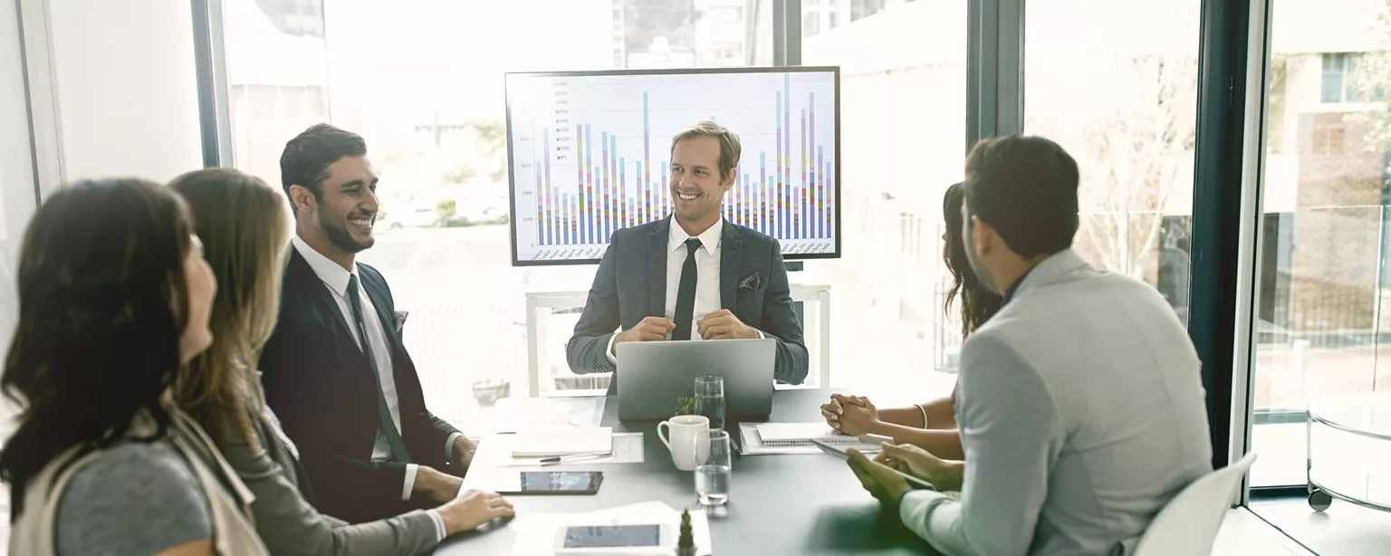 HR leaders reviewing workforce analytics during a team meeting in a conference room.