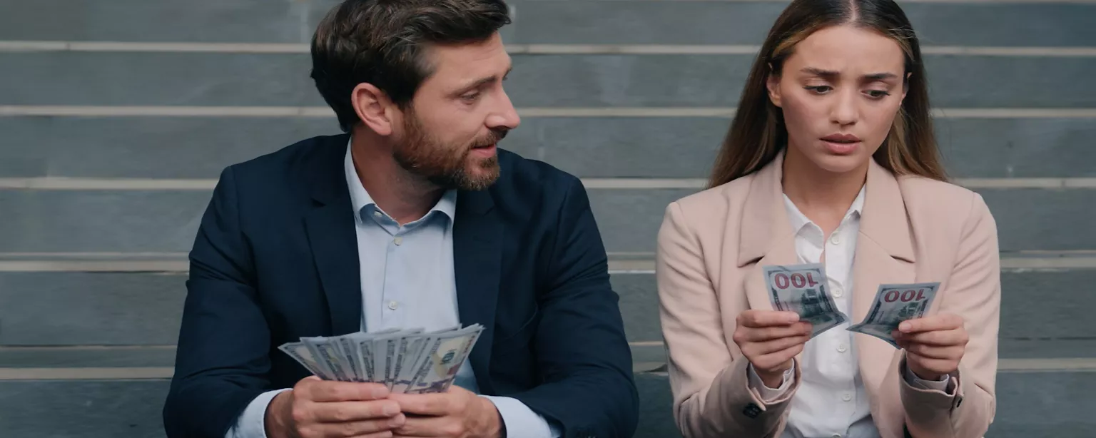 Glücklicher Geschäftsmann mit viel Geld, lächelt, während eine Geschäftsfrau mit geringem Gehalt, traurig ist.