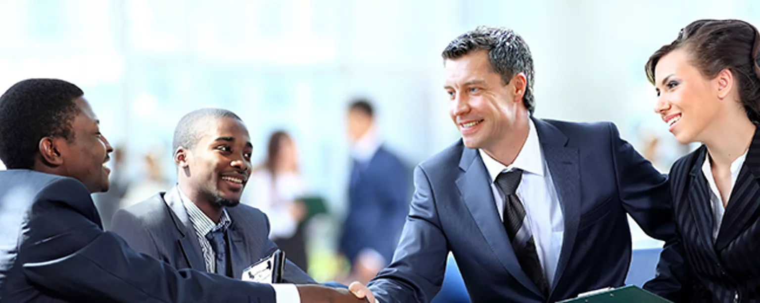 Four professionals in finance positions, two shaking hands