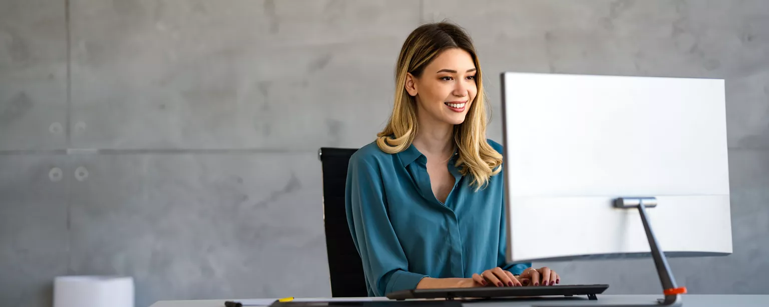 Professional woman working at a computer in an office.