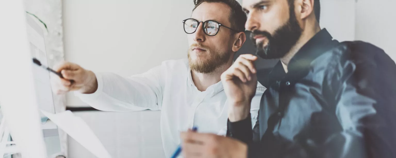 Image of a brand manager working with a colleague at a computer.