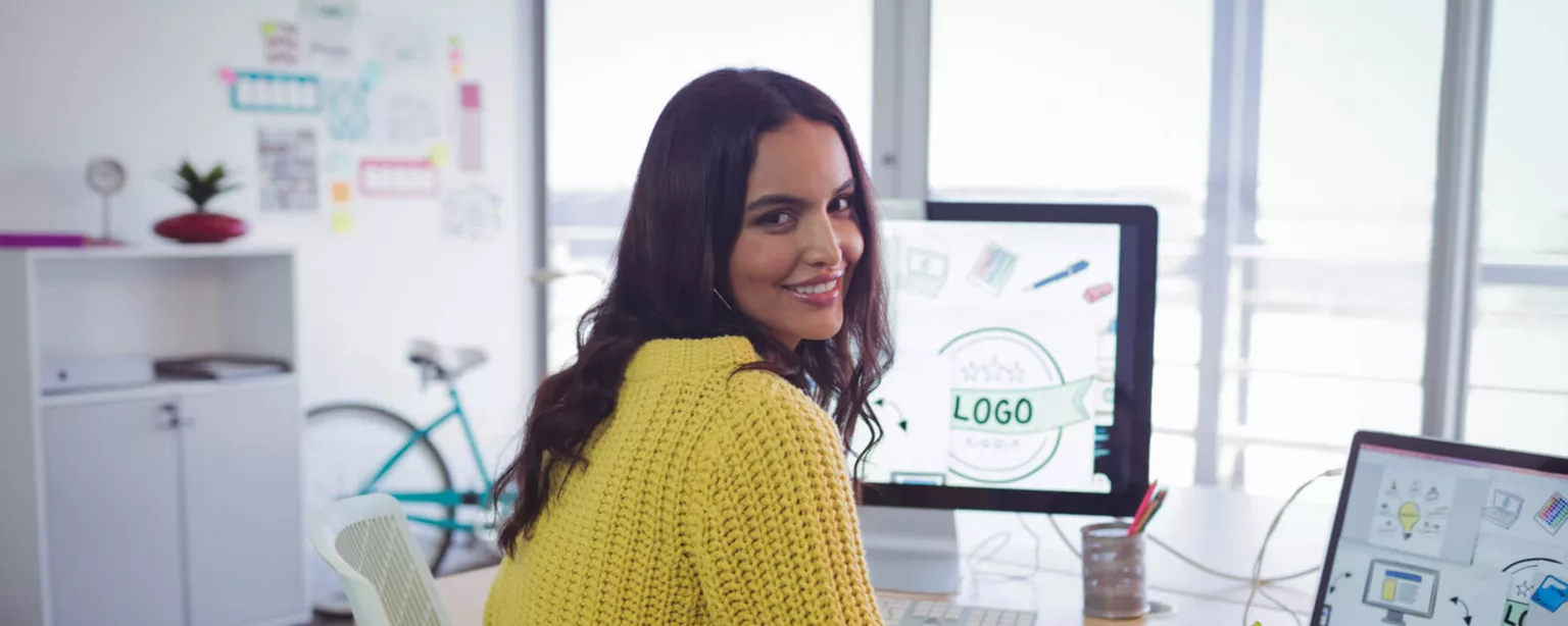 A graphic designer sitting at her computer in an office.