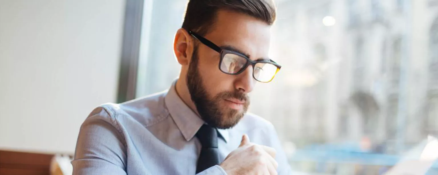 How to Review Resumes — man at office desk holding pen and paper