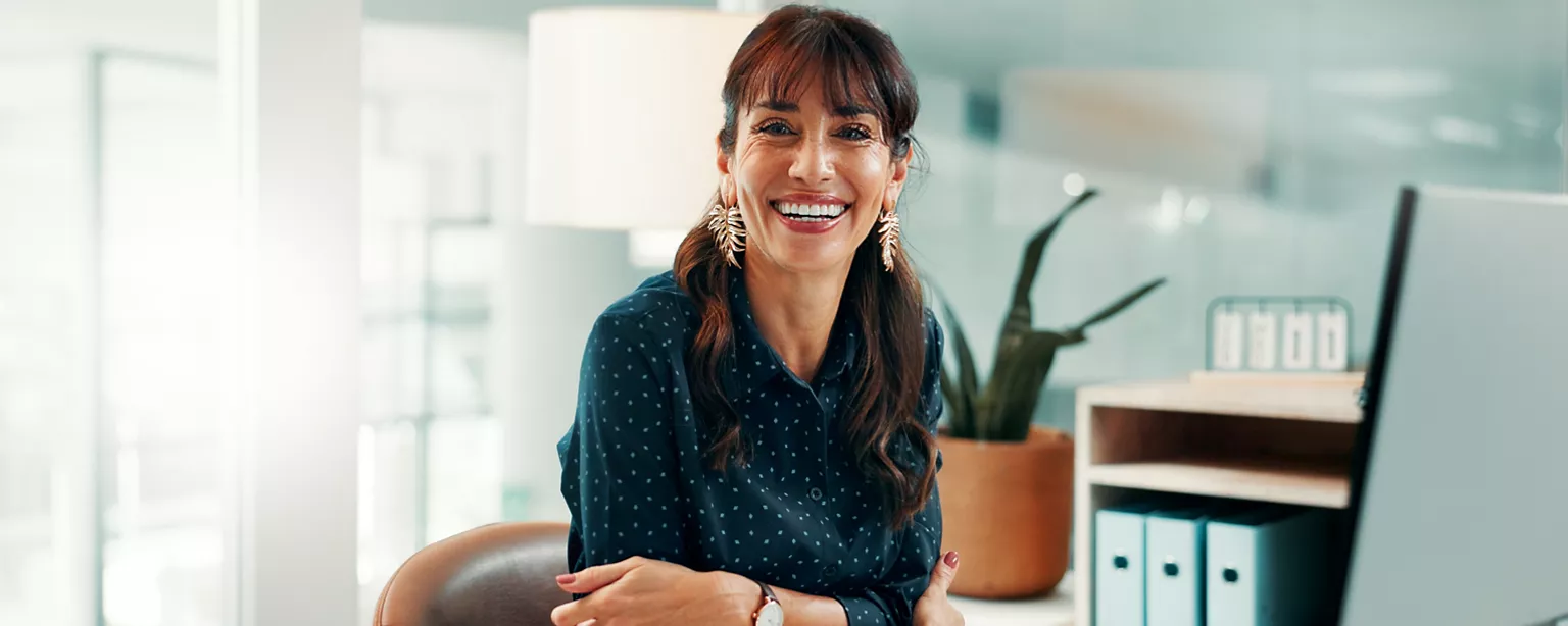 businesswoman turning from desk to look at camera