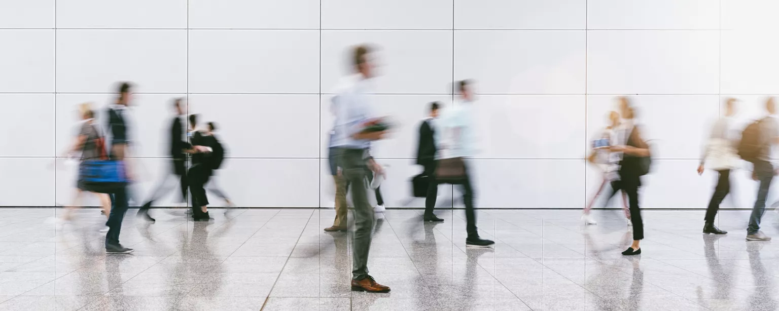 business people and workers walking in a crowd in a blur