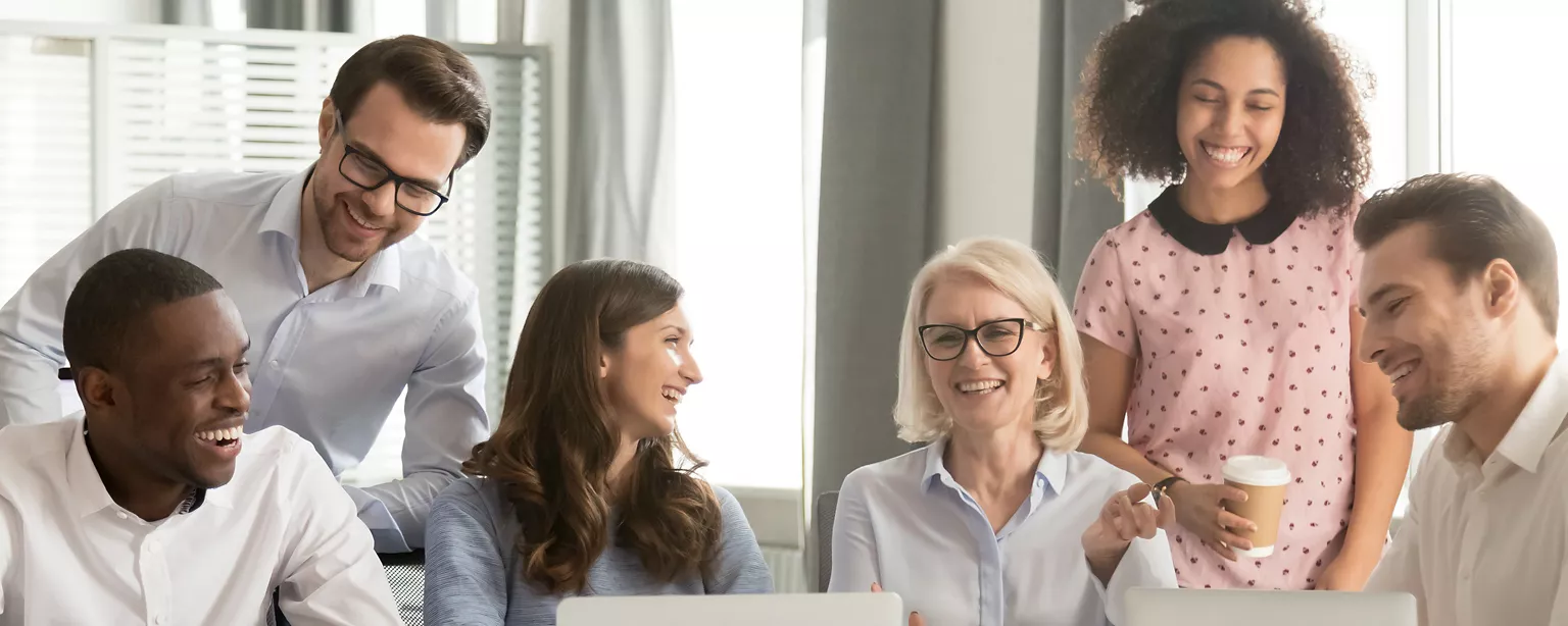 Team in an office, chatting and laughing.