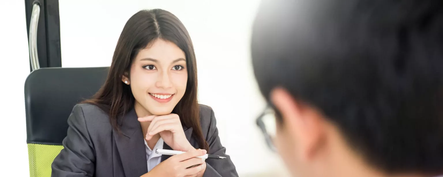 Image of an interviewer meeting with a smiling job seeker.