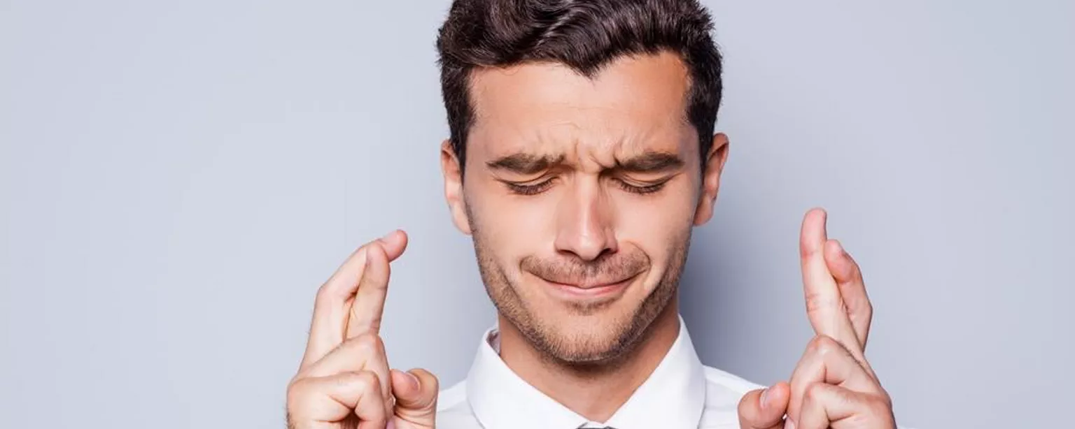 A job seeker waits with fingers crossed for the results of the hiring process