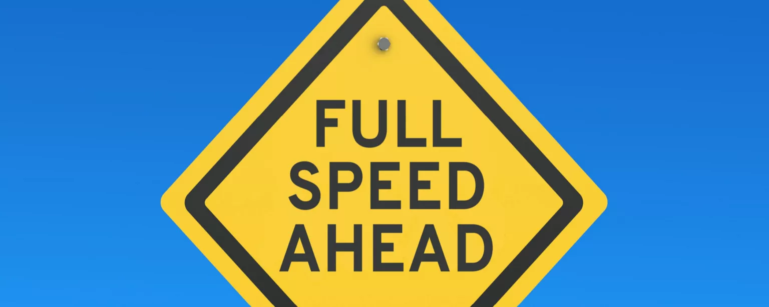Diamond-shaped yellow road sign against a blue background that says, "Full Speed Ahead" in black lettering.
