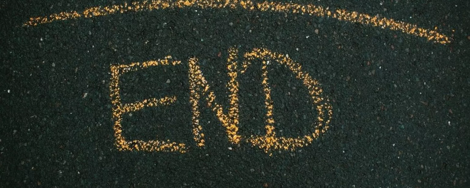 Das Wort “End” mit gelber Kreide auf Asphalt geschrieben
