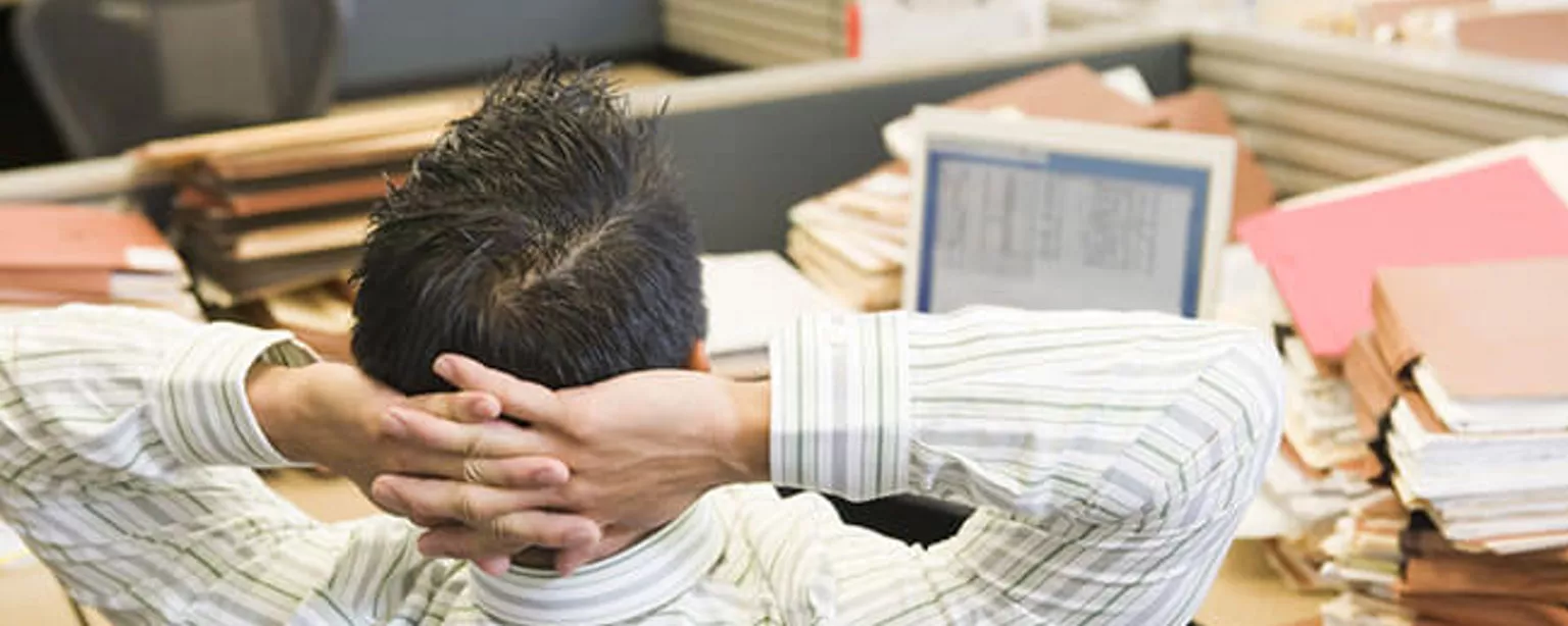 CFO at a desk piled with files