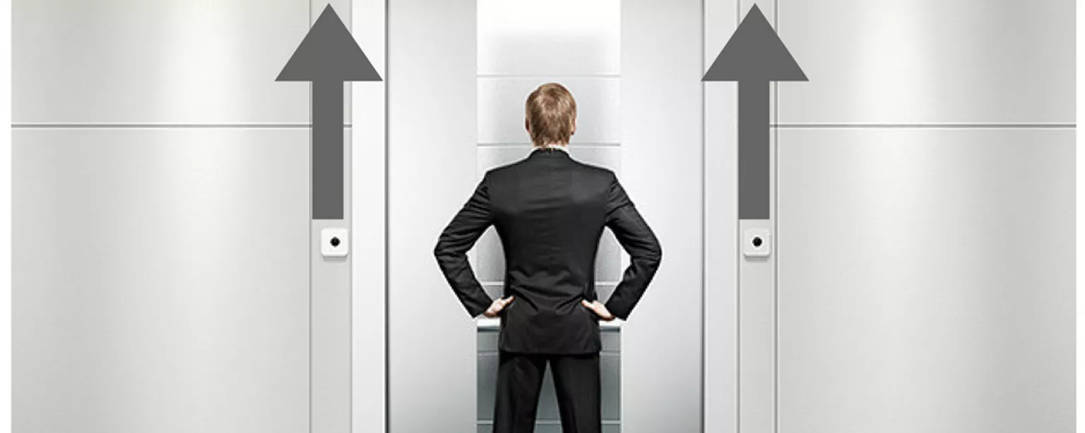 Man standing in front of elevator going up