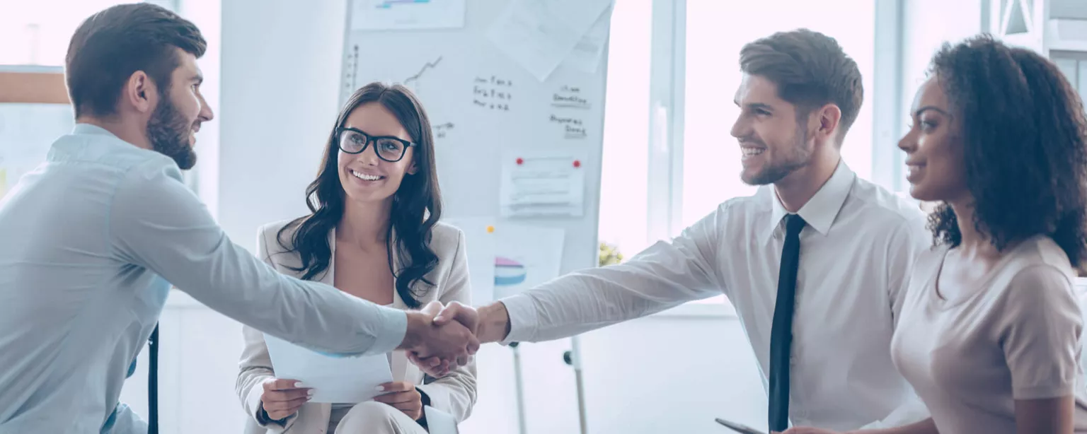 A group of four employees meeting during a new hire orientation program.