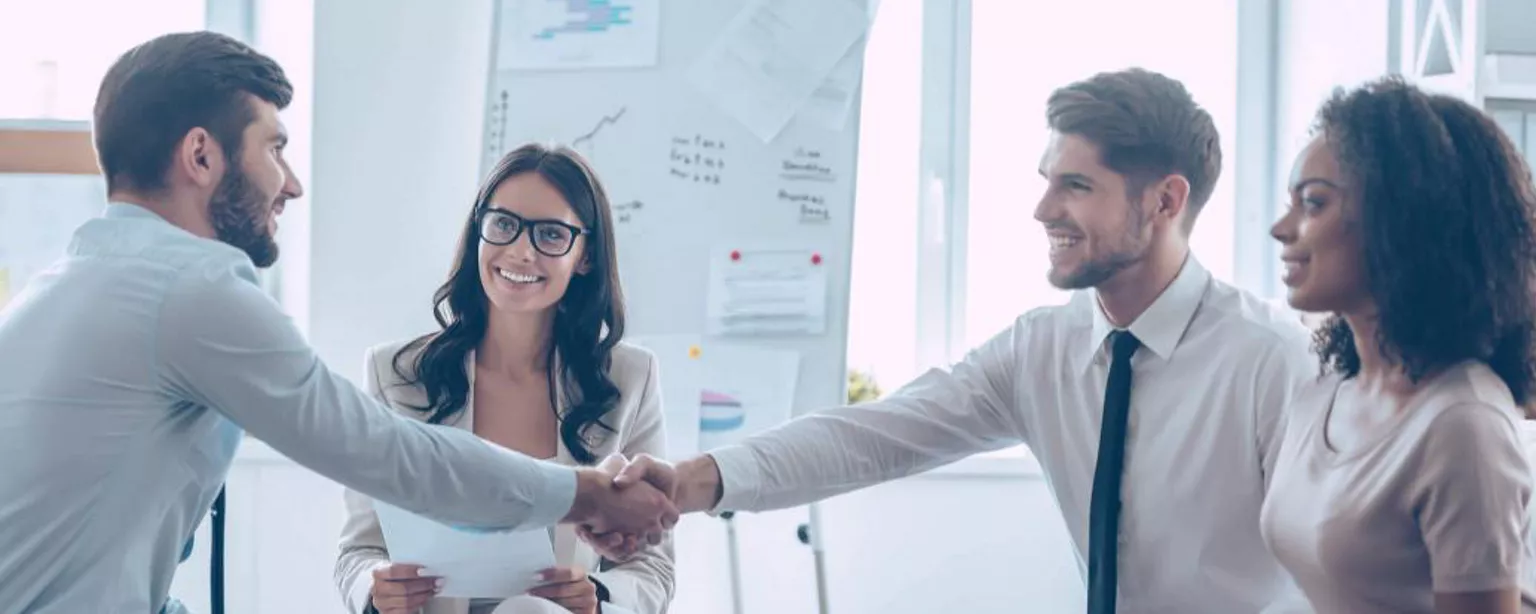 A group of four employees meeting during a new hire orientation program.