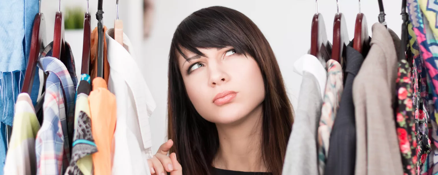 An administrative assistant searches her closet for the right office attire