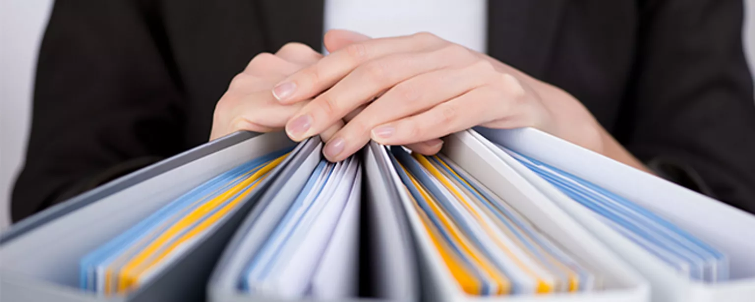 What You Need to Know to Get That Payroll Professional Salary — closeup of person's hands on four notebooks