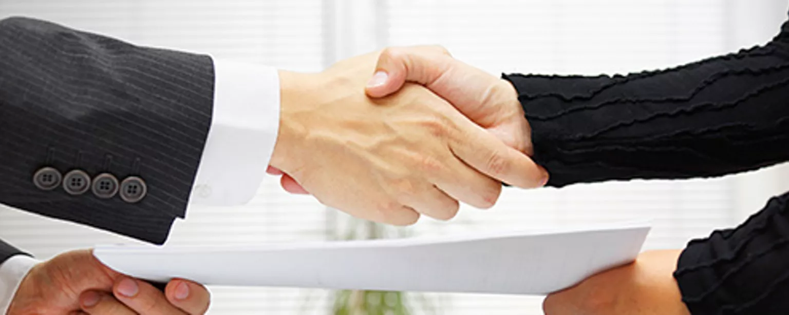 Get Ready to Negotiate Your Legal Secretary Salary — two sets of hands shake after negotiating a salary