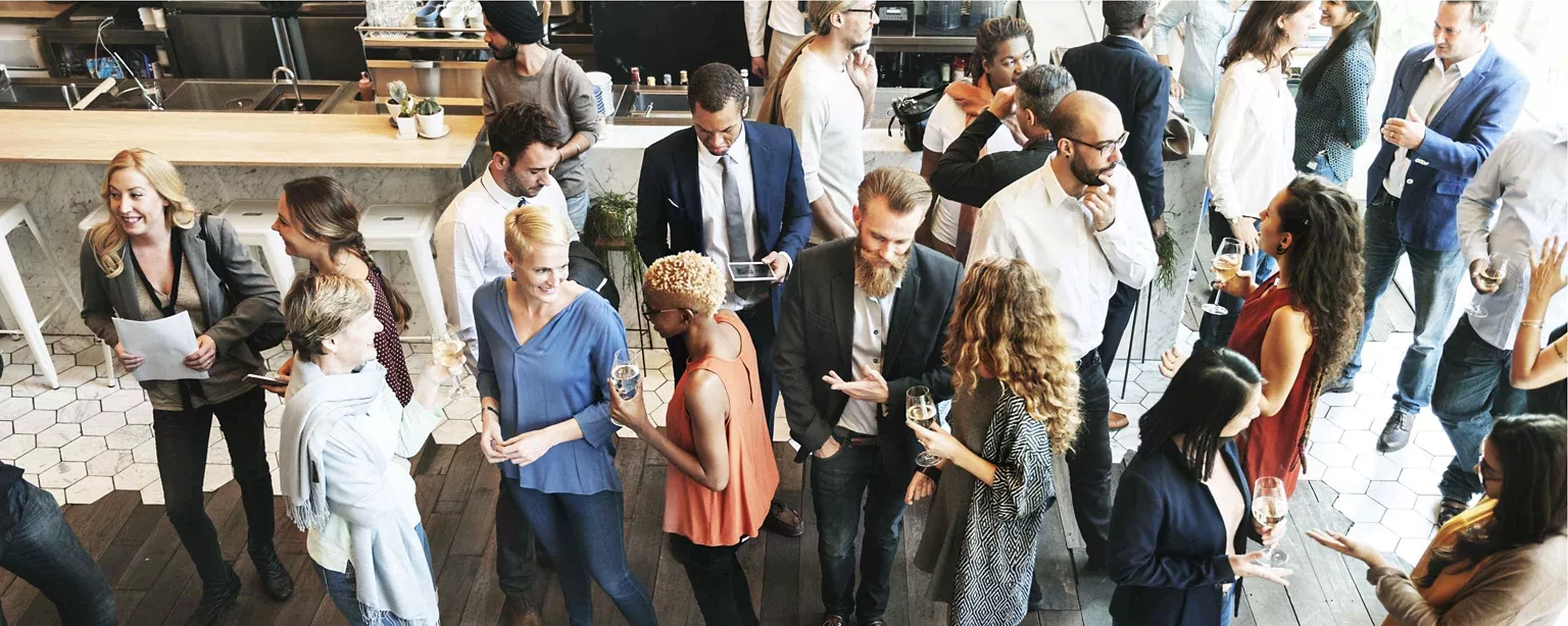 A diverse group of professionals networking and socializing at a casual business event.