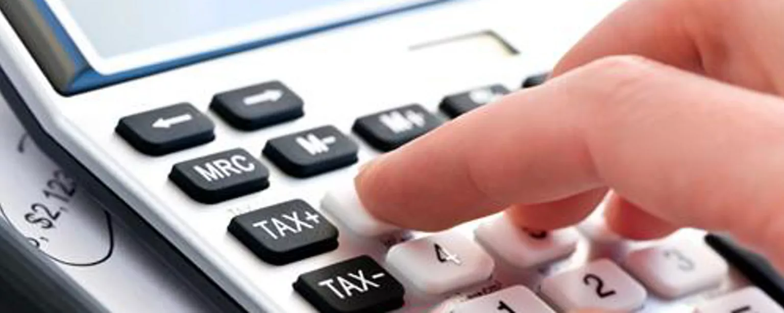 Hand on calculator figuring accounts payable salary