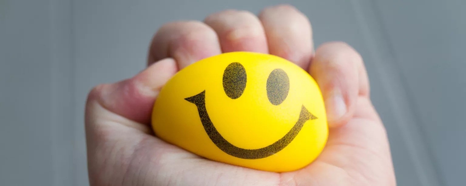 Photo of a hand squeezing a stress ball.