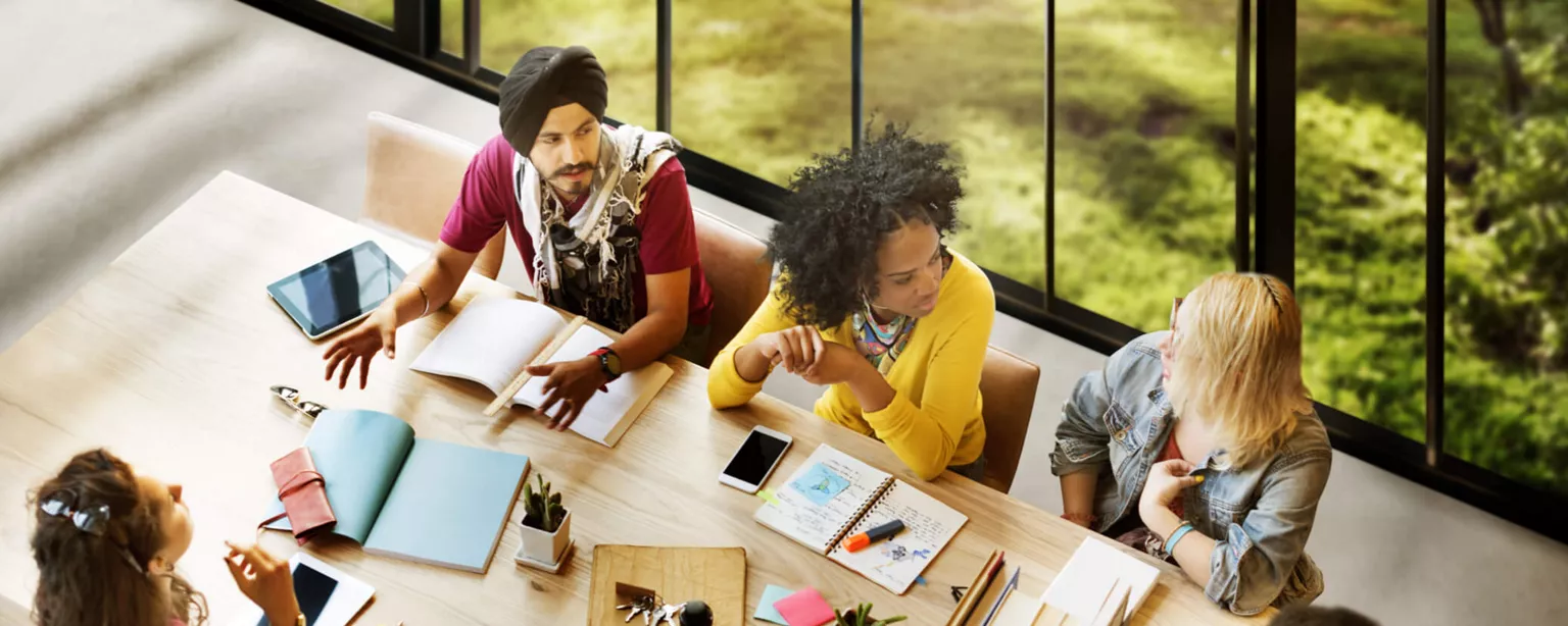 Diverse group of employees brainstorming in a conference room.