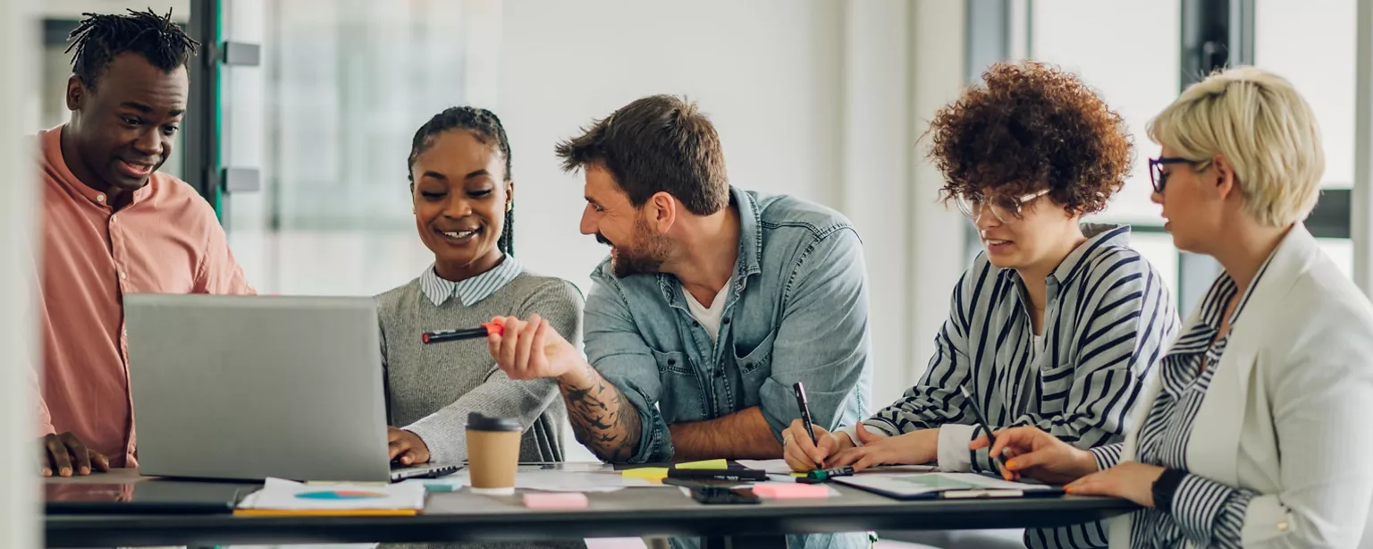 A diverse team of employees brainstorm about ways to improve workflow as they share ideas.