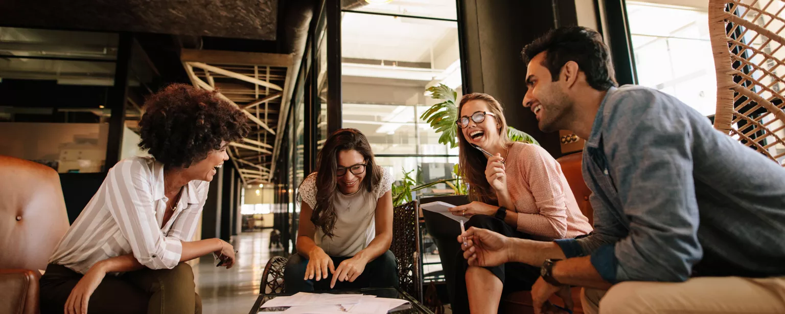 Creative professionals laughing during a meeting