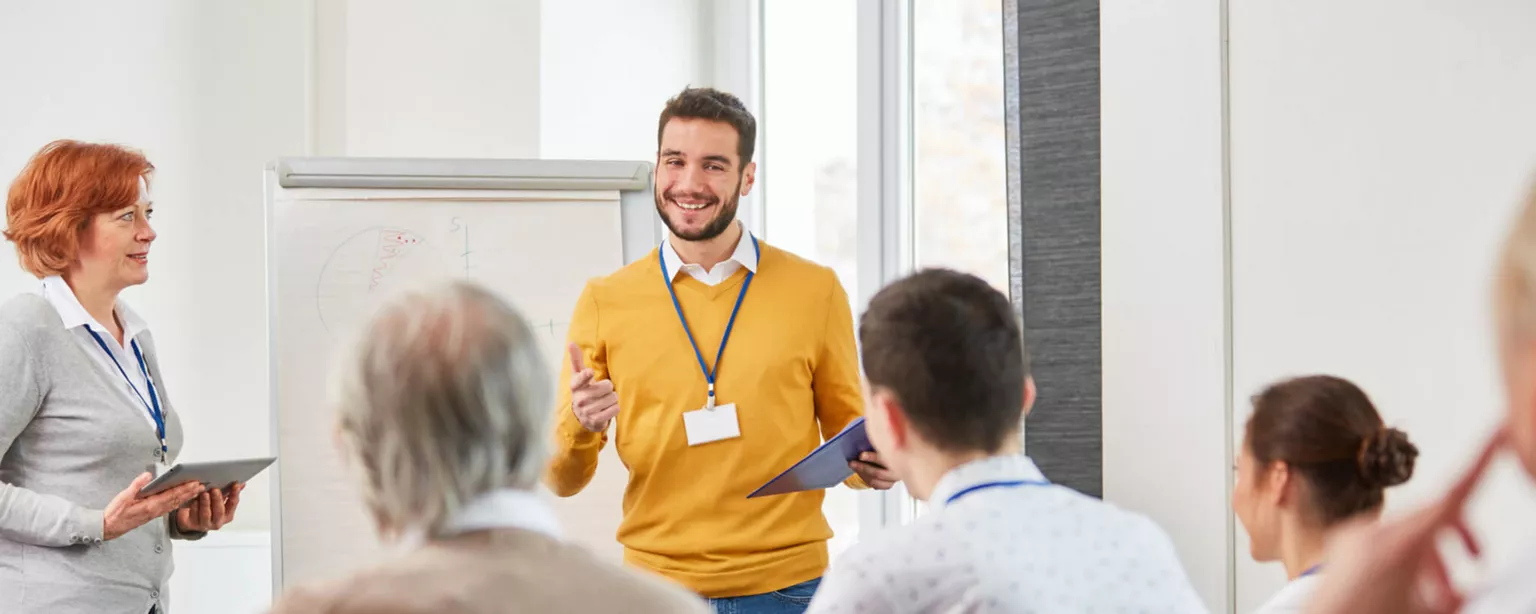 Photo of an upskilling event where an employee is presenting to seated colleagues. 