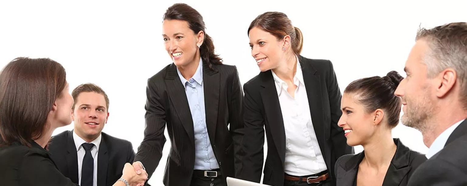 Zakenvrouwen en -mannen begroeten nieuwe collega