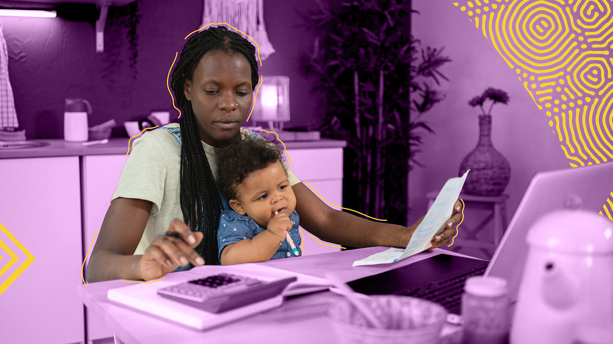A mother calculating her taxes with a toddler on her lap.