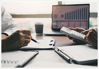 Two people at a desk crunching numbers