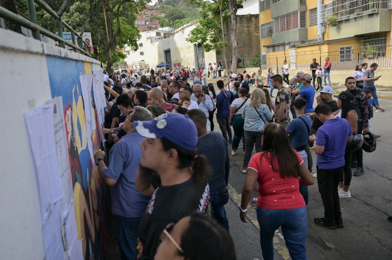 Pessoas procuram seus nomes em uma seção eleitoral durante a eleição presidencial em Caracas 